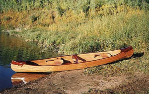 side view Stitch and Glue 16' Canoe on lake shore